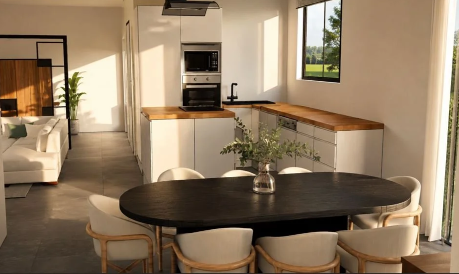 Intérieur d'une cuisine ouverte à Saint Laurent de Chamousset avec une table ronde noire entourée de chaises blanches, vue sur un salon avec canapé blanc. Conception par Nadine Saguin, architecte d'intérieure et décoratrice à Mions, Rhône.