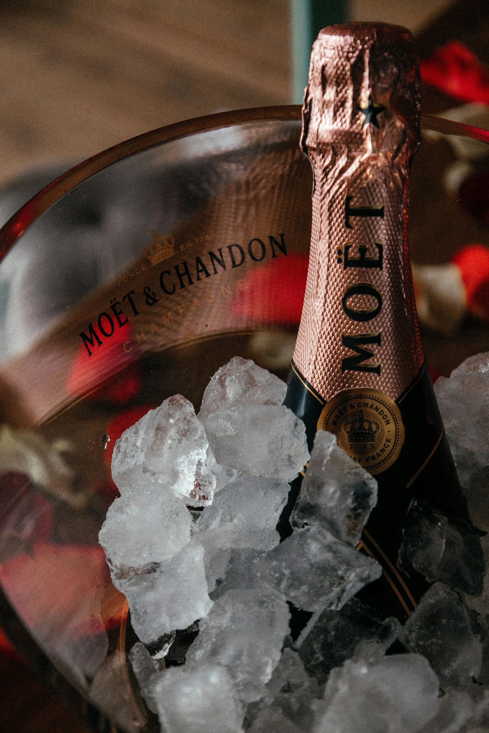 A bottle of Moët & Chandon champagne in a silver ice bucket filled with ice cubes.