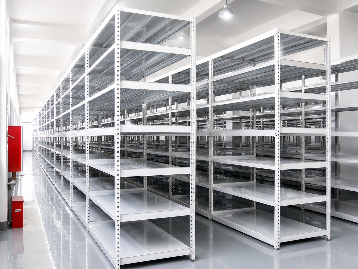 Empty industrial metal shelving units in a clean warehouse with bright lighting.
