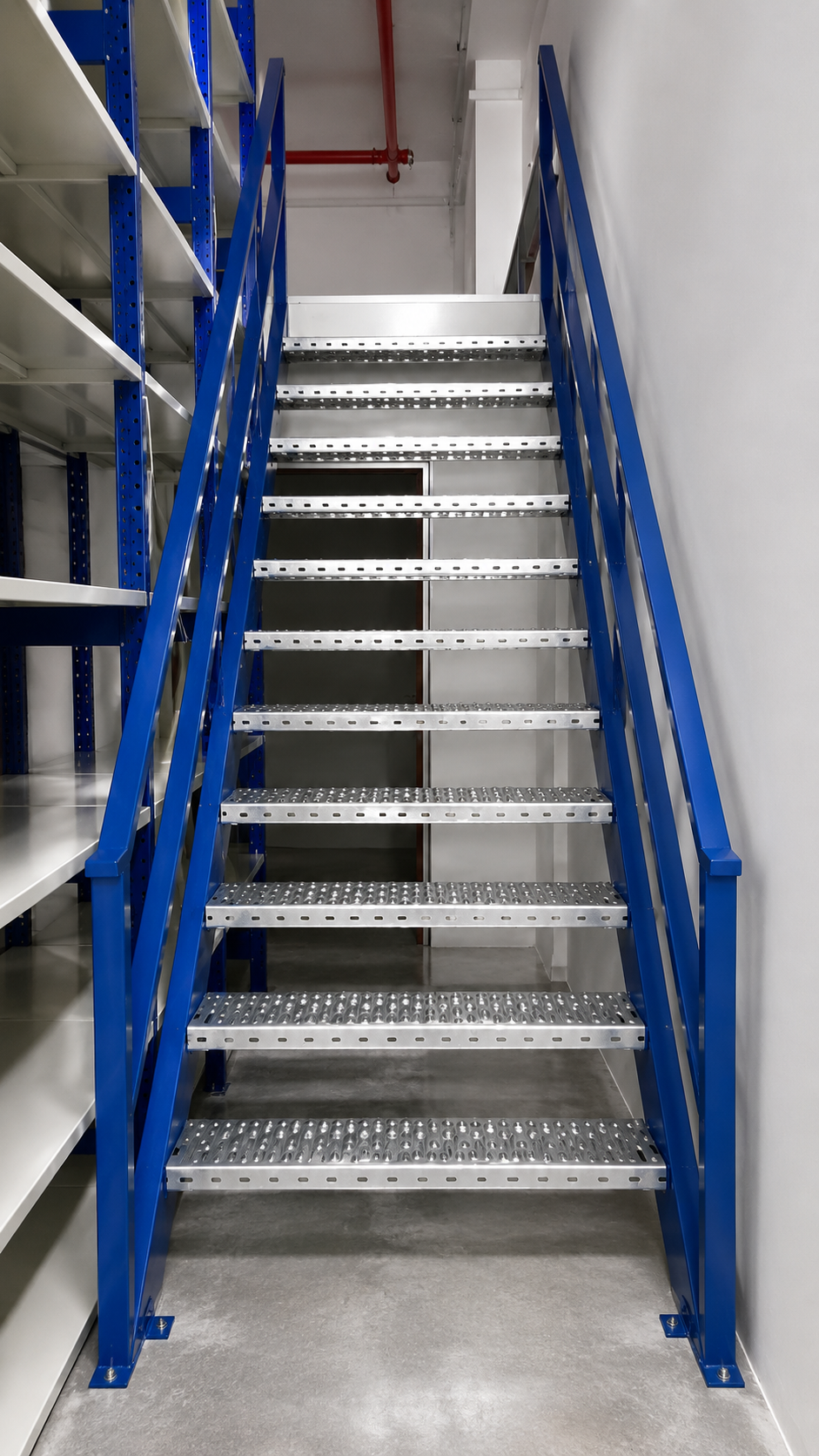 Metal staircase with blue handrails leading up to a door in a storage or industrial space.