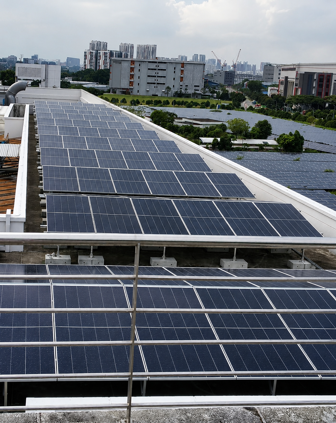 View of solar panels installed on a building rooftop with cityscape in the background.