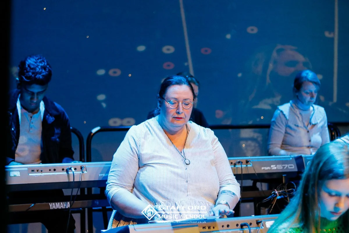 Women playing electronic keyboards during a music performance or practice