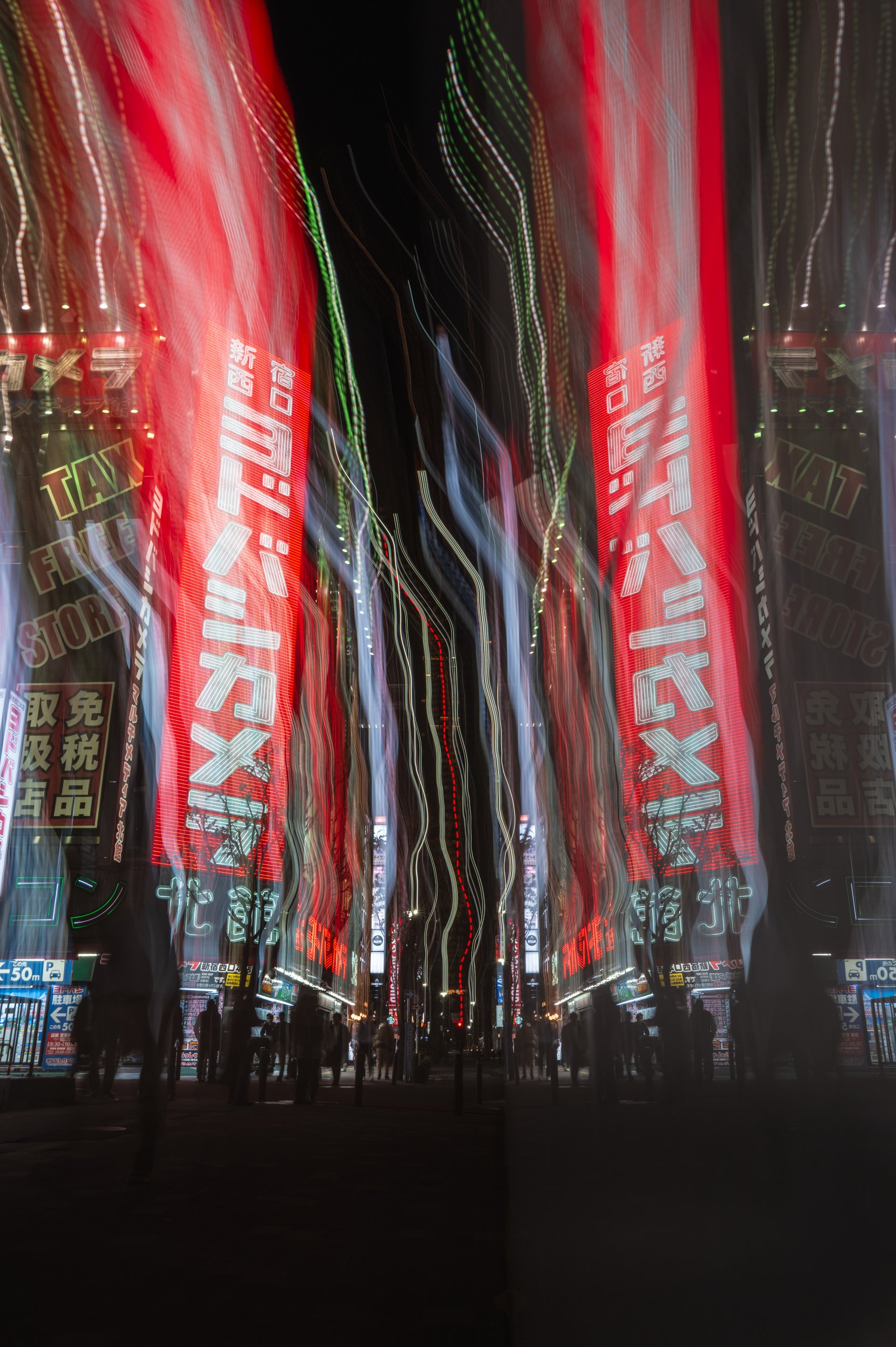 Night scene of a busy city street with tall buildings illuminated by colorful neon signs and lights, creating a wavy, distorted effect.