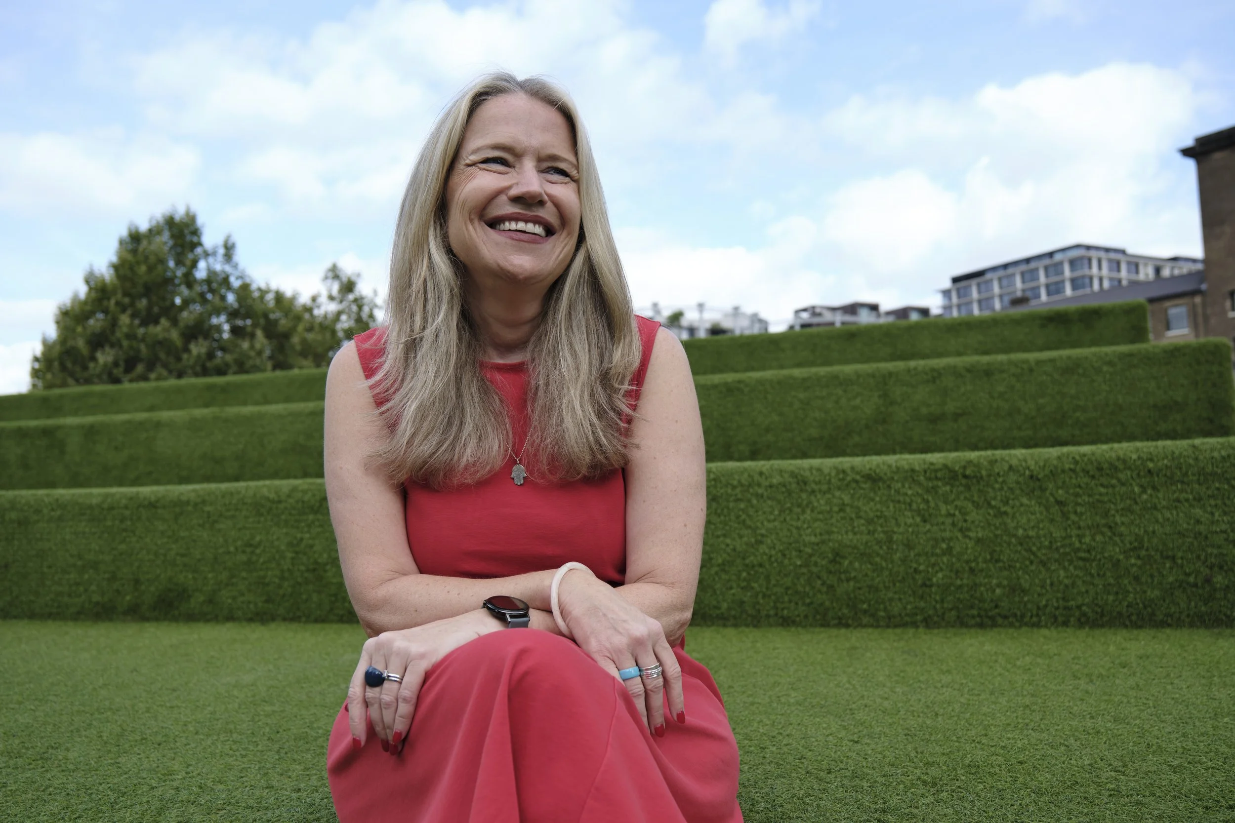 Debbie Porter sitting on a well-manicured grassy area.