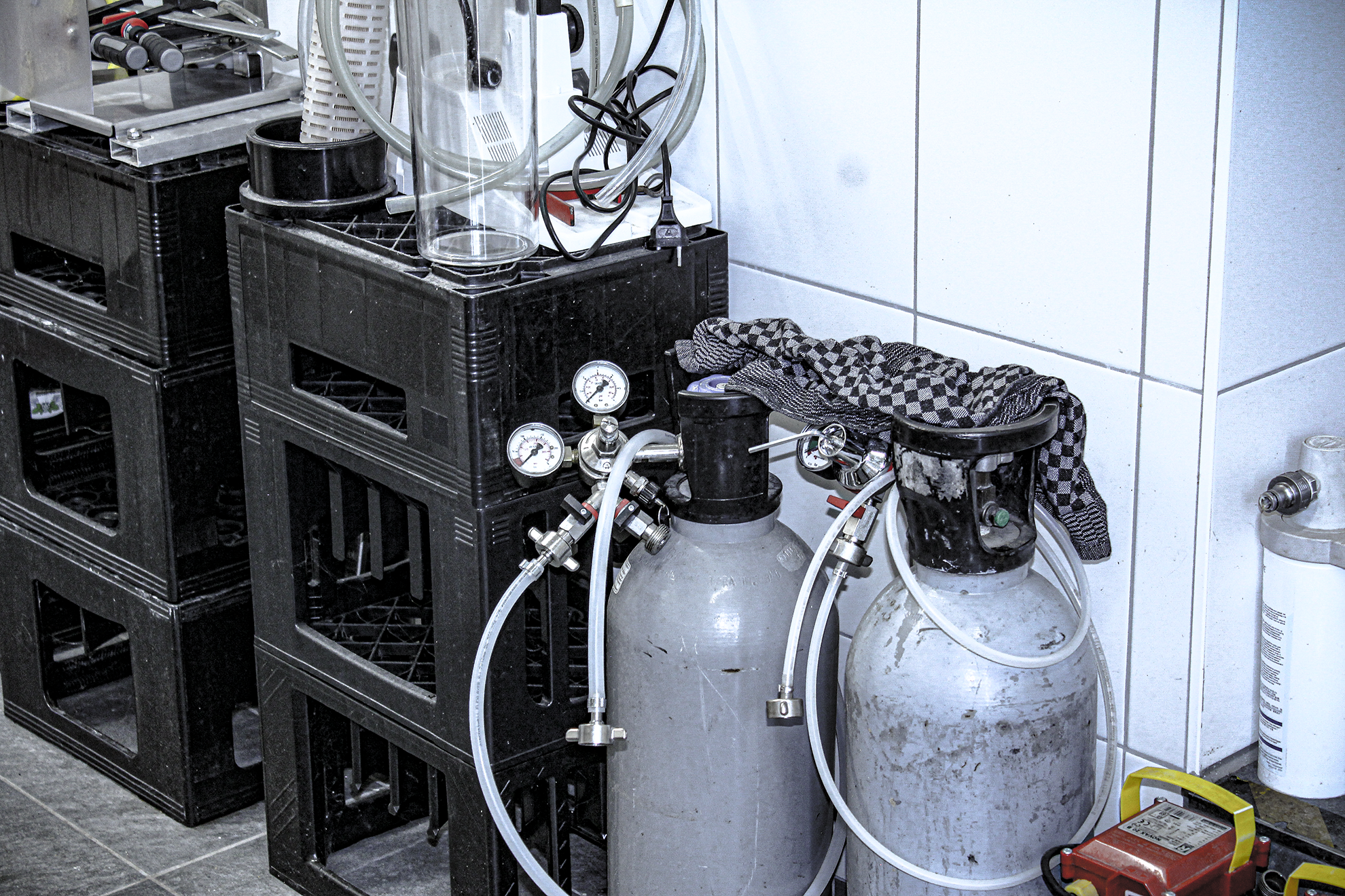 Laborgeräte mit Druckmanometern, Schläuchen und Gasflaschen, die möglicherweise in einem Labor oder technischem Umfeld verwendet werden.