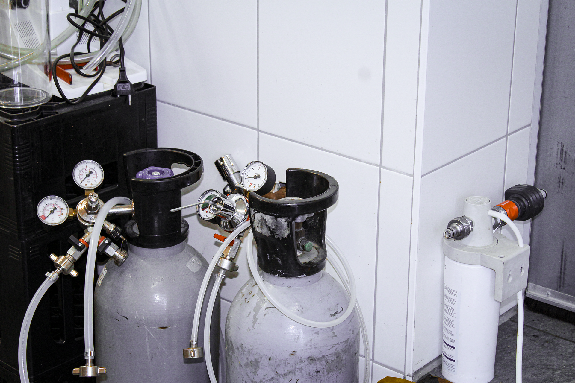Chemische Geräte und Gasezylinder in einem Laborraum.