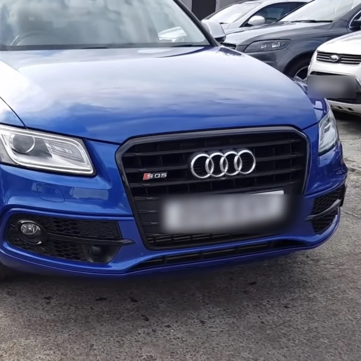 Blue Audi S4 car parked in a lot with other vehicles visible in the background.