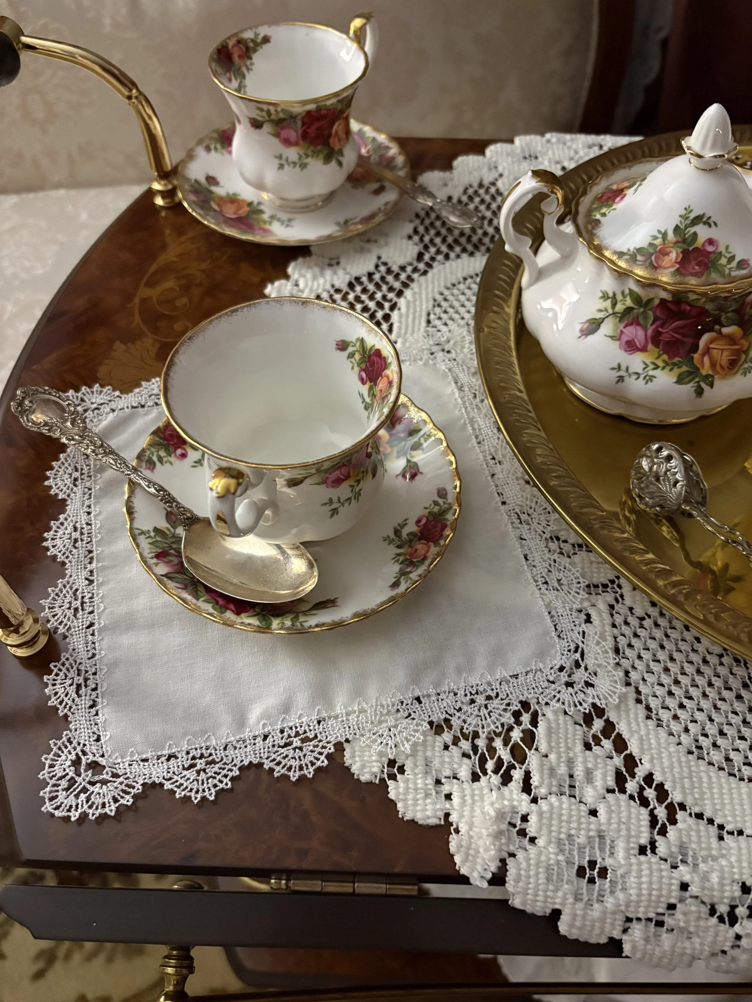 Vintage tea set and lace handkerchief styled in a Victorian cottage setting, linking to Evening Shade Cottage on Pinterest.