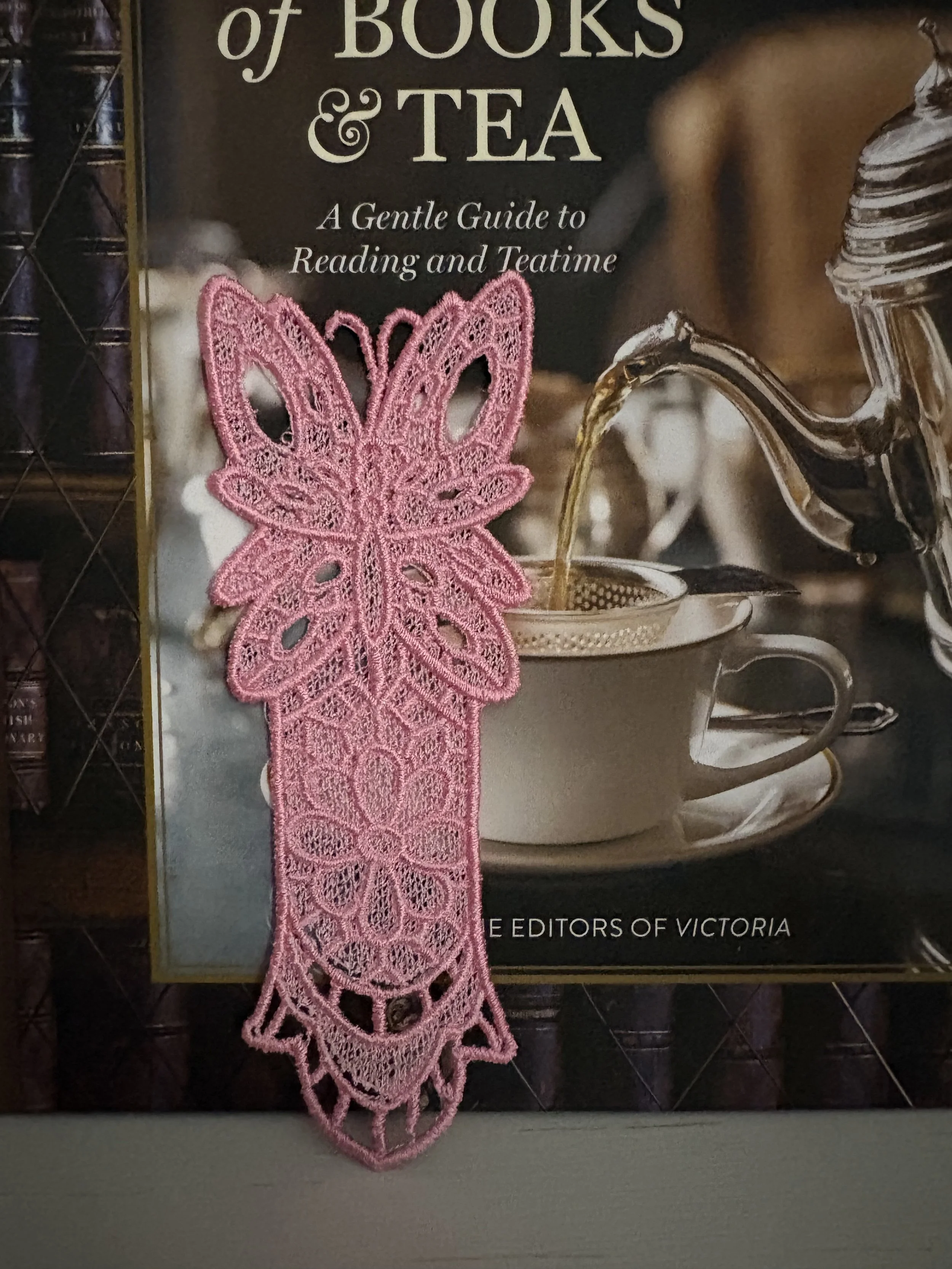 Free-standing lace butterfly bookmark embroidered in soft pink thread with intricate Victorian-inspired lace details.