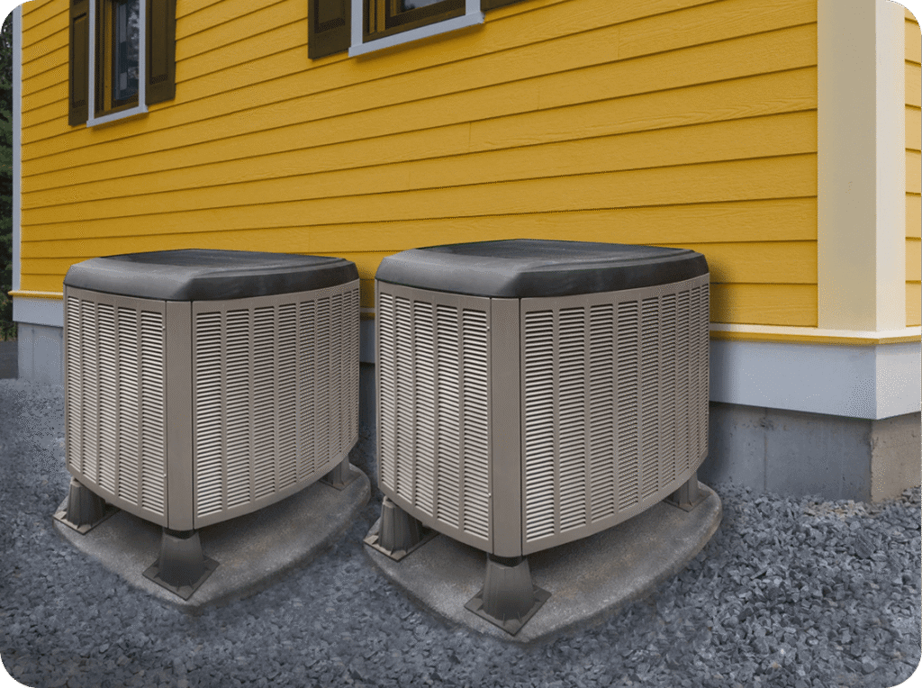 Two air conditioning units outside a yellow house with black shutters.