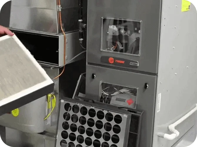 Close-up of an HVAC or environmental testing chamber with a person removing a filter.