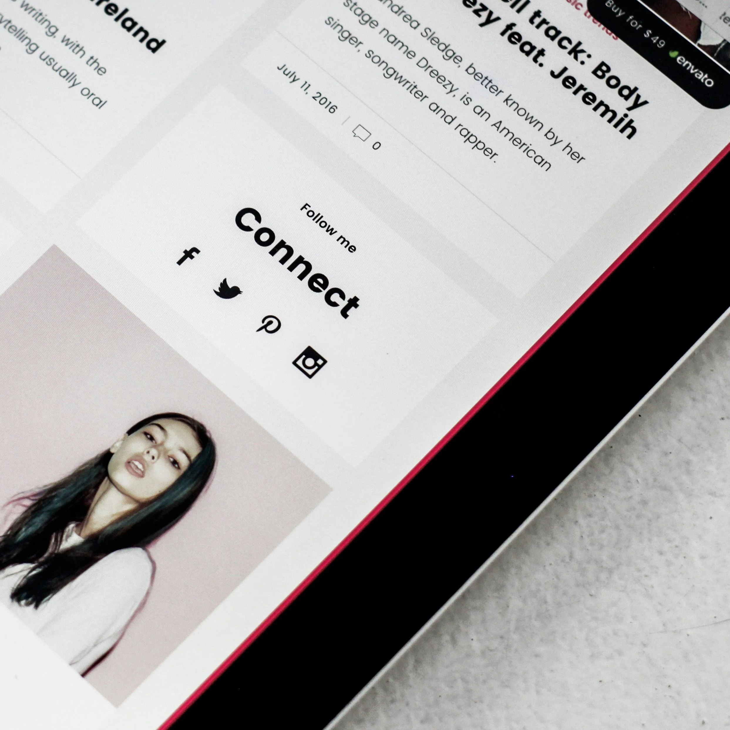A close-up of a printed webpage featuring a young woman's portrait and text about body admiration and self-confidence, with social media icons at the bottom.