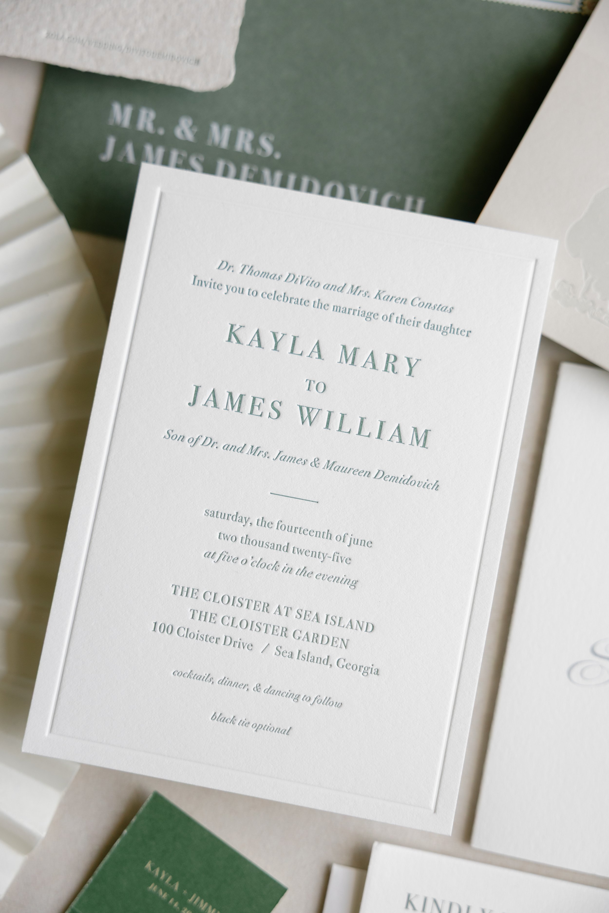 Close-up of wedding invitation card with details about the celebration of Kayla Mary and James William's marriage, including date and location.