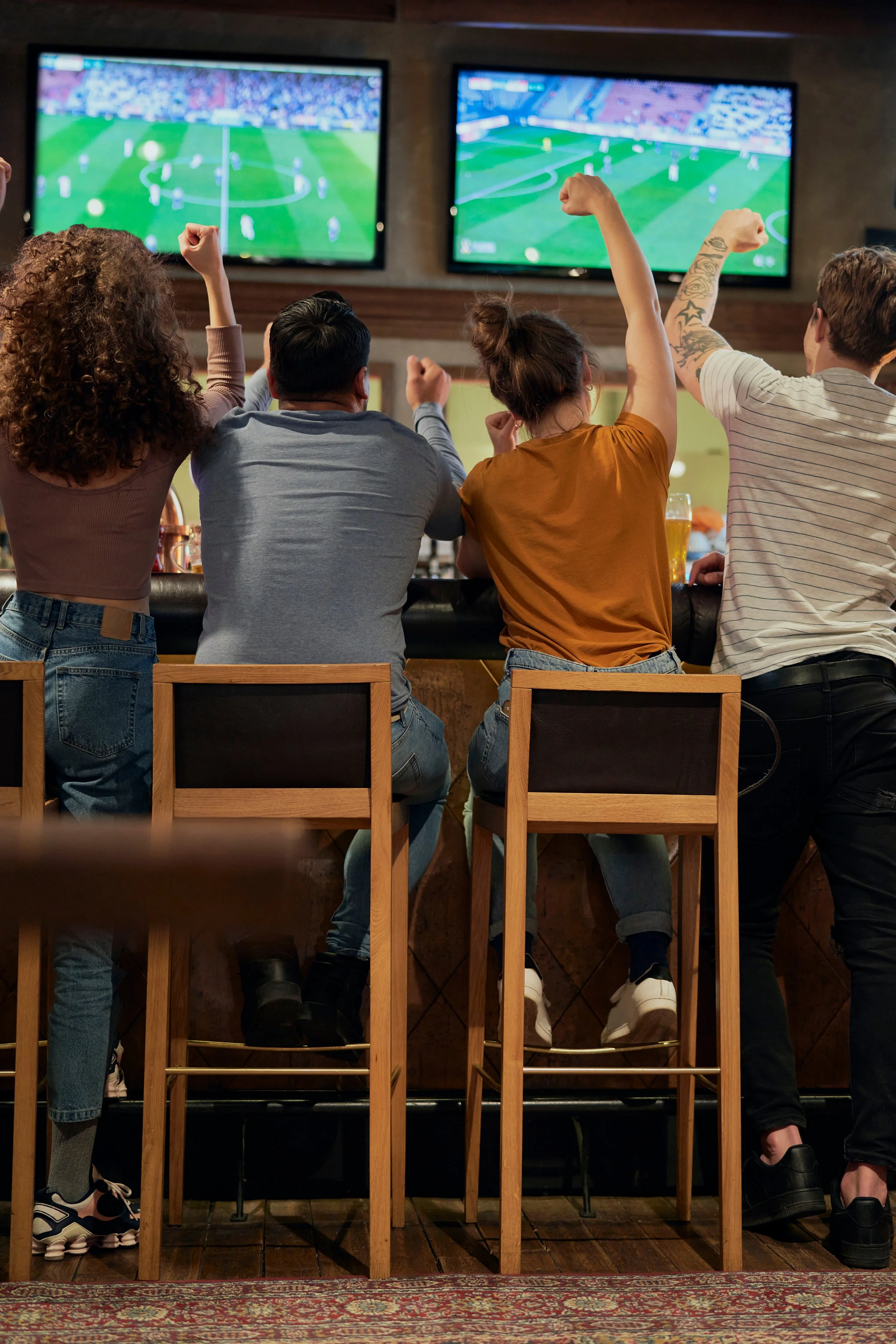 Group of People cheering for their soccer team at a bar