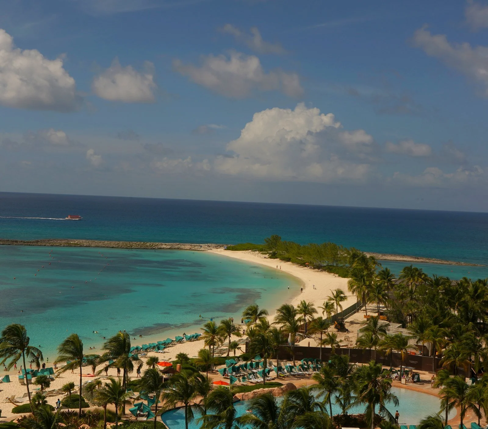 Aerial view of a turquoise lagoon, white-sand beach, and palms. © Vyretho LLC