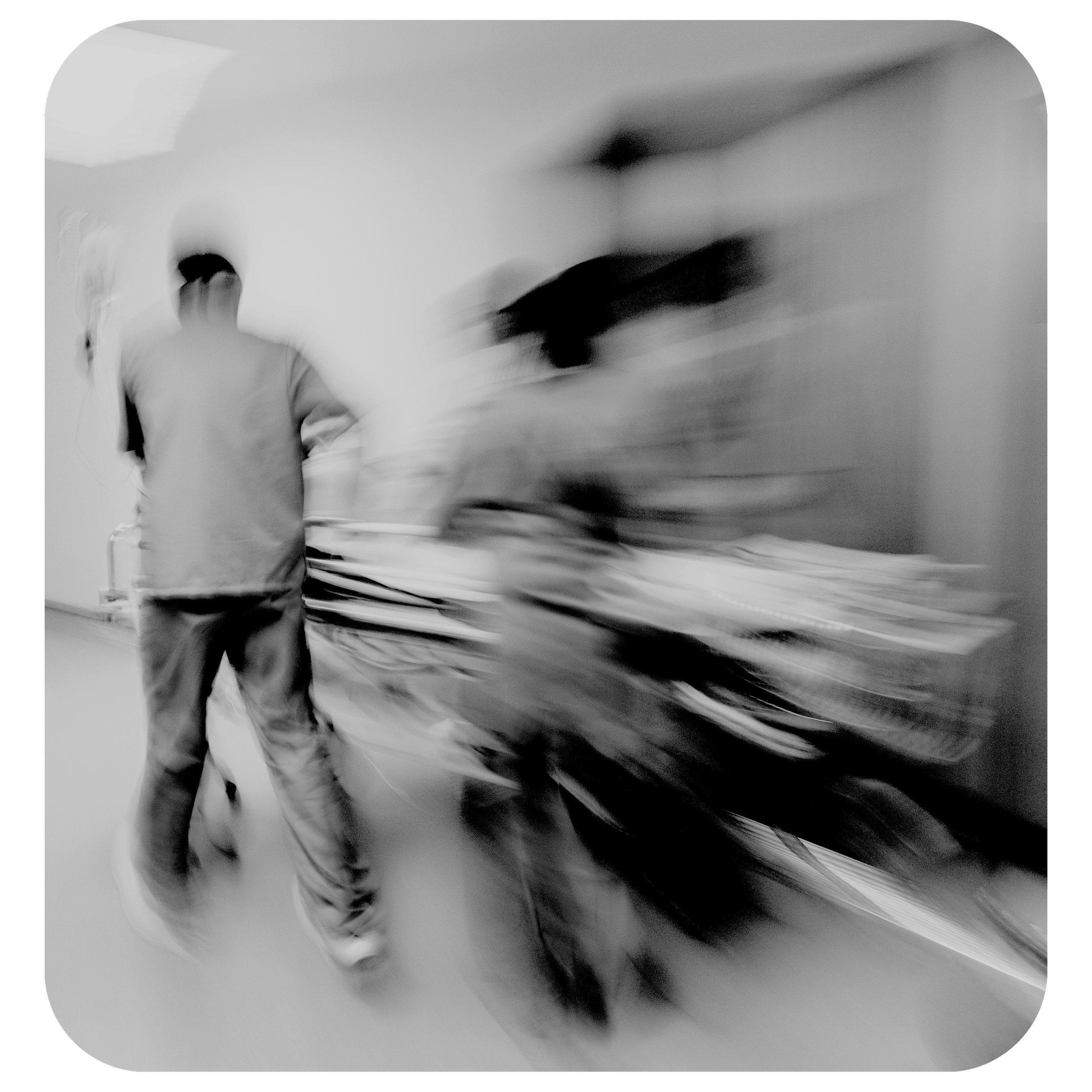 Blurred black and white image of a person in motion, making it difficult to distinguish details.
