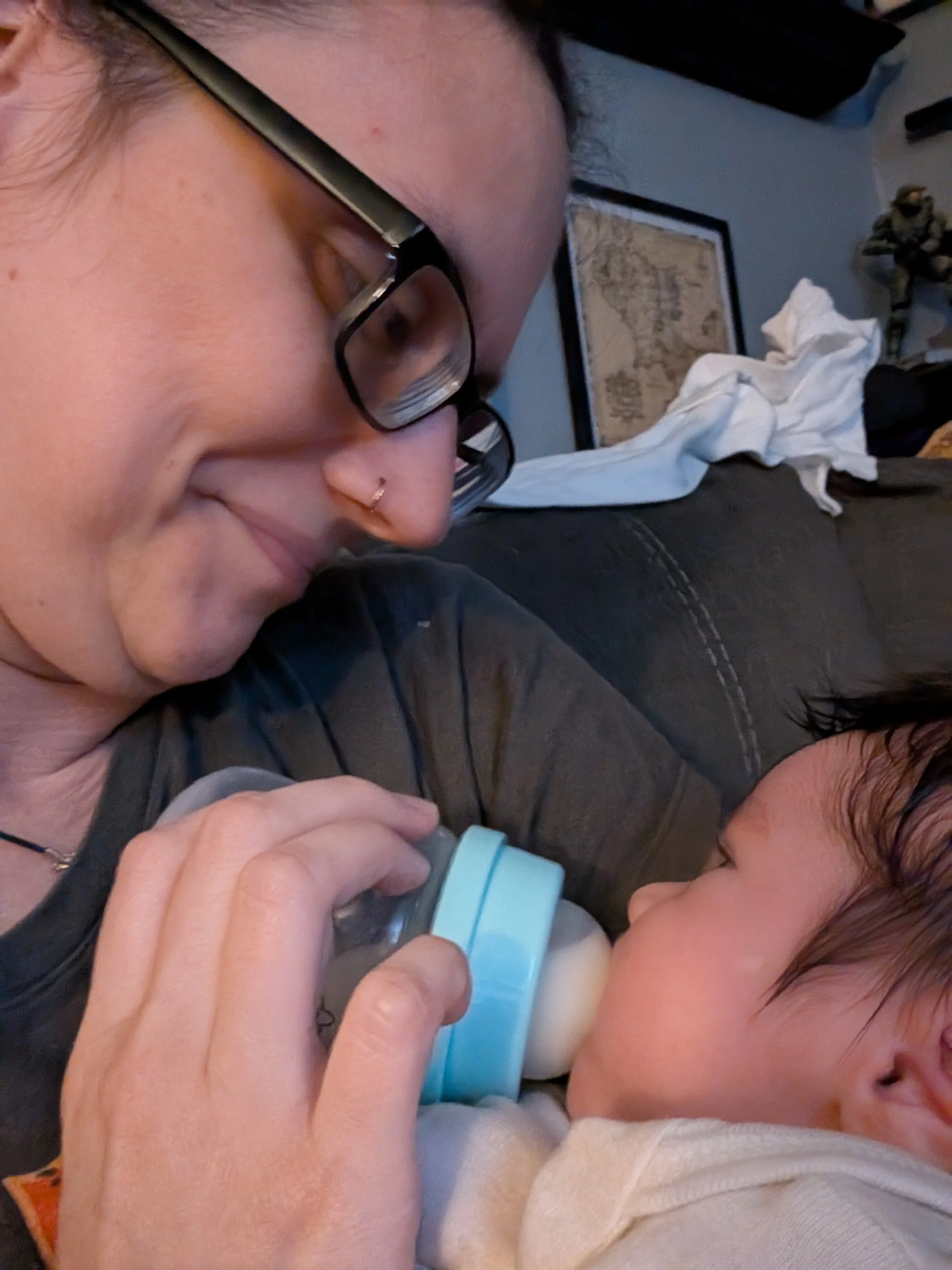 Doula supporting family by feeding baby while mom naps
