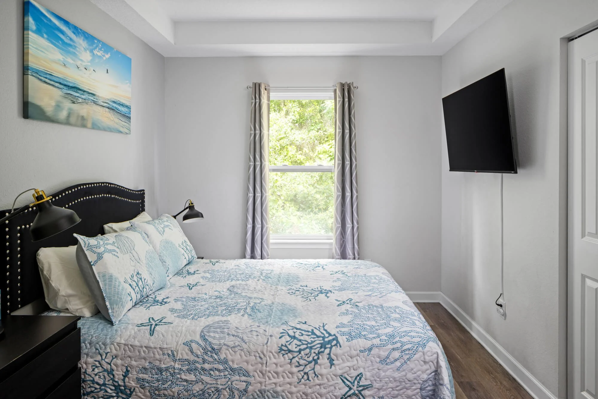 Queen guest bedroom with TV and coastal bedding