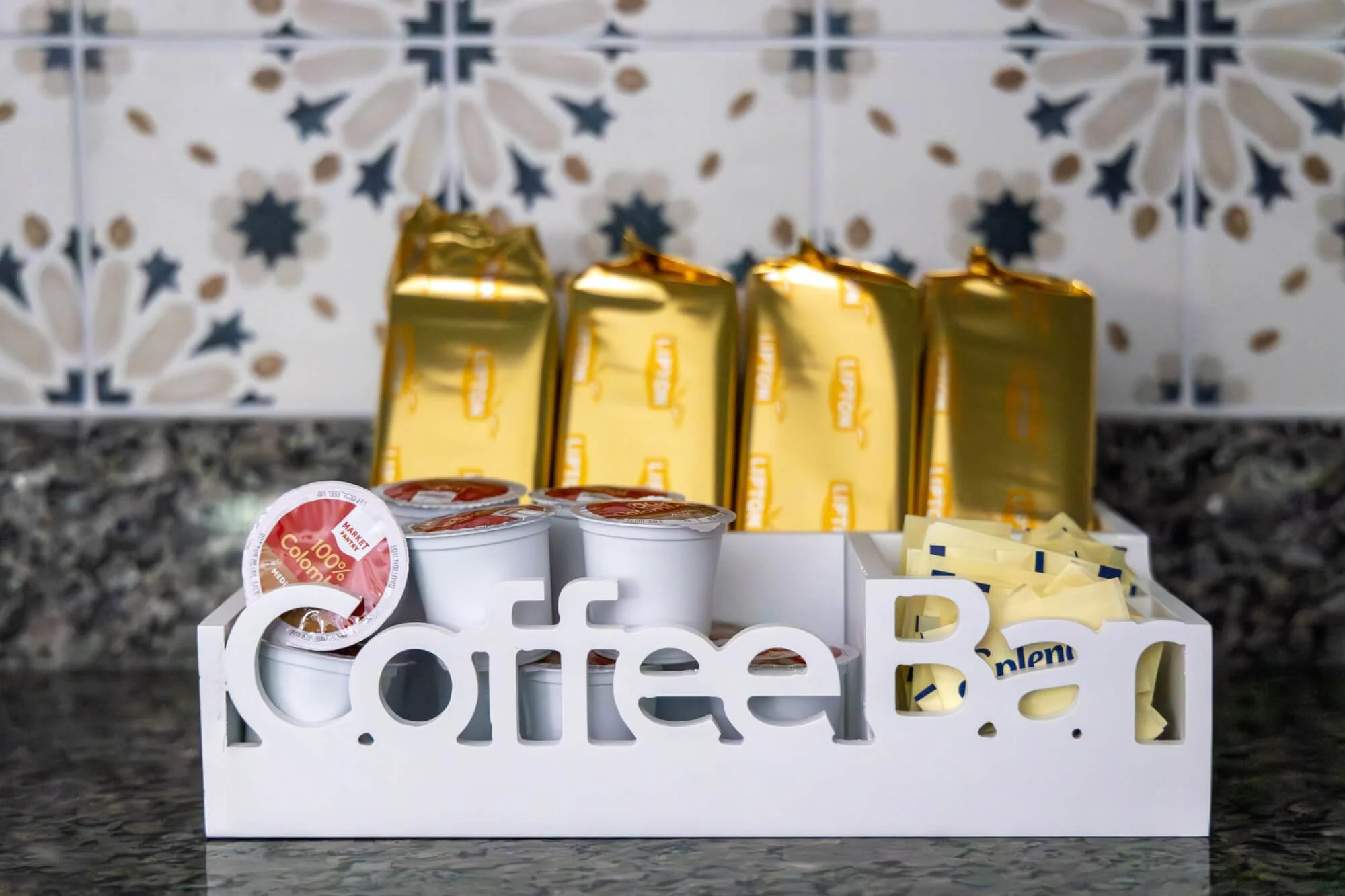 Stocked coffee bar with K-cups, tea, and sweeteners