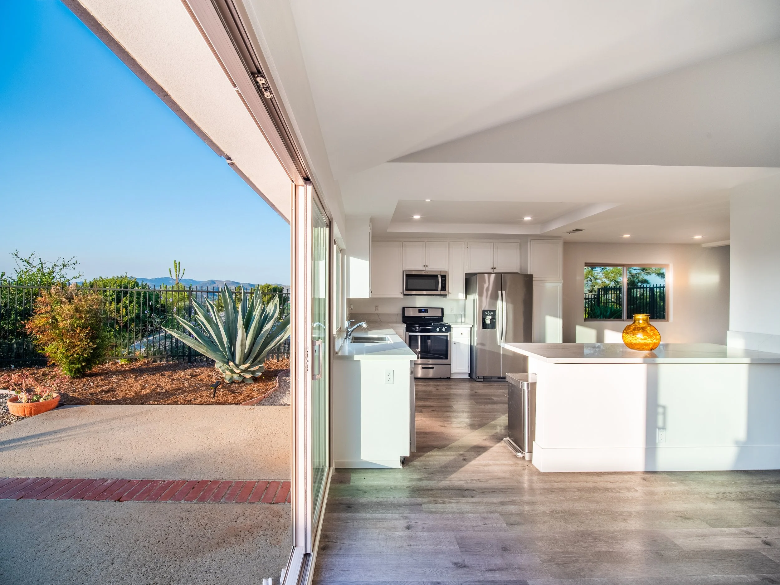 large floor-to-ceiling slider doors open up fully bringing the outdoors, indoor