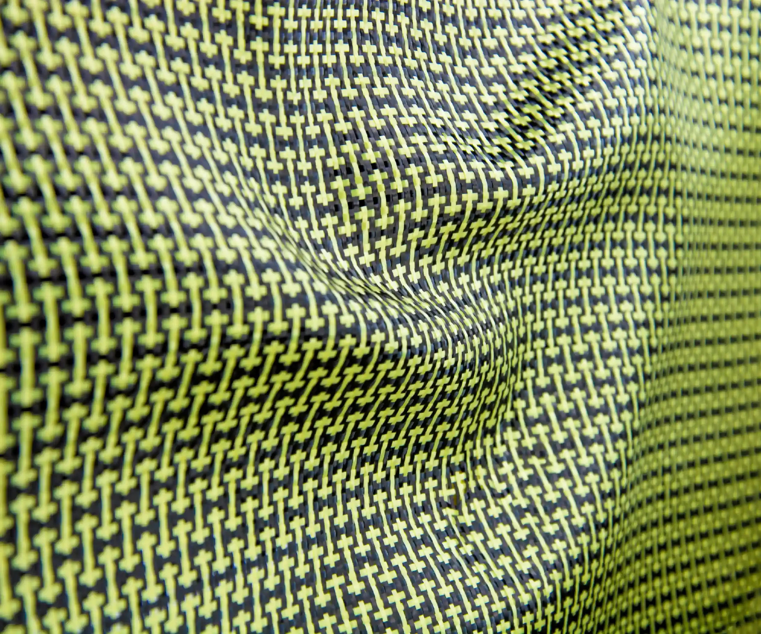 Close-up of a vibrant, patterned fabric featuring small yellow crosses on a black background.