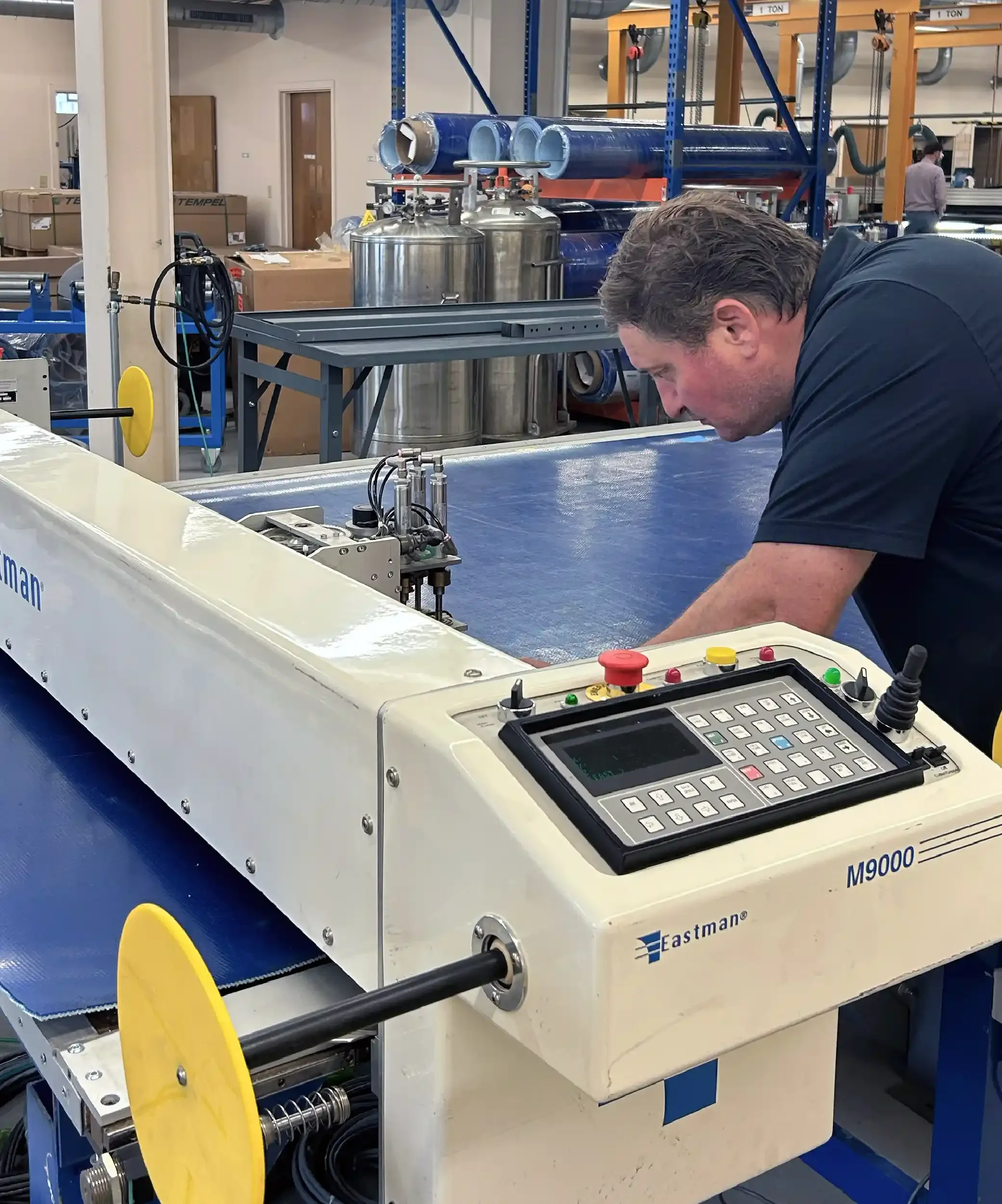 A person working on a precision cutting machine machine in a manufacturing facility.
