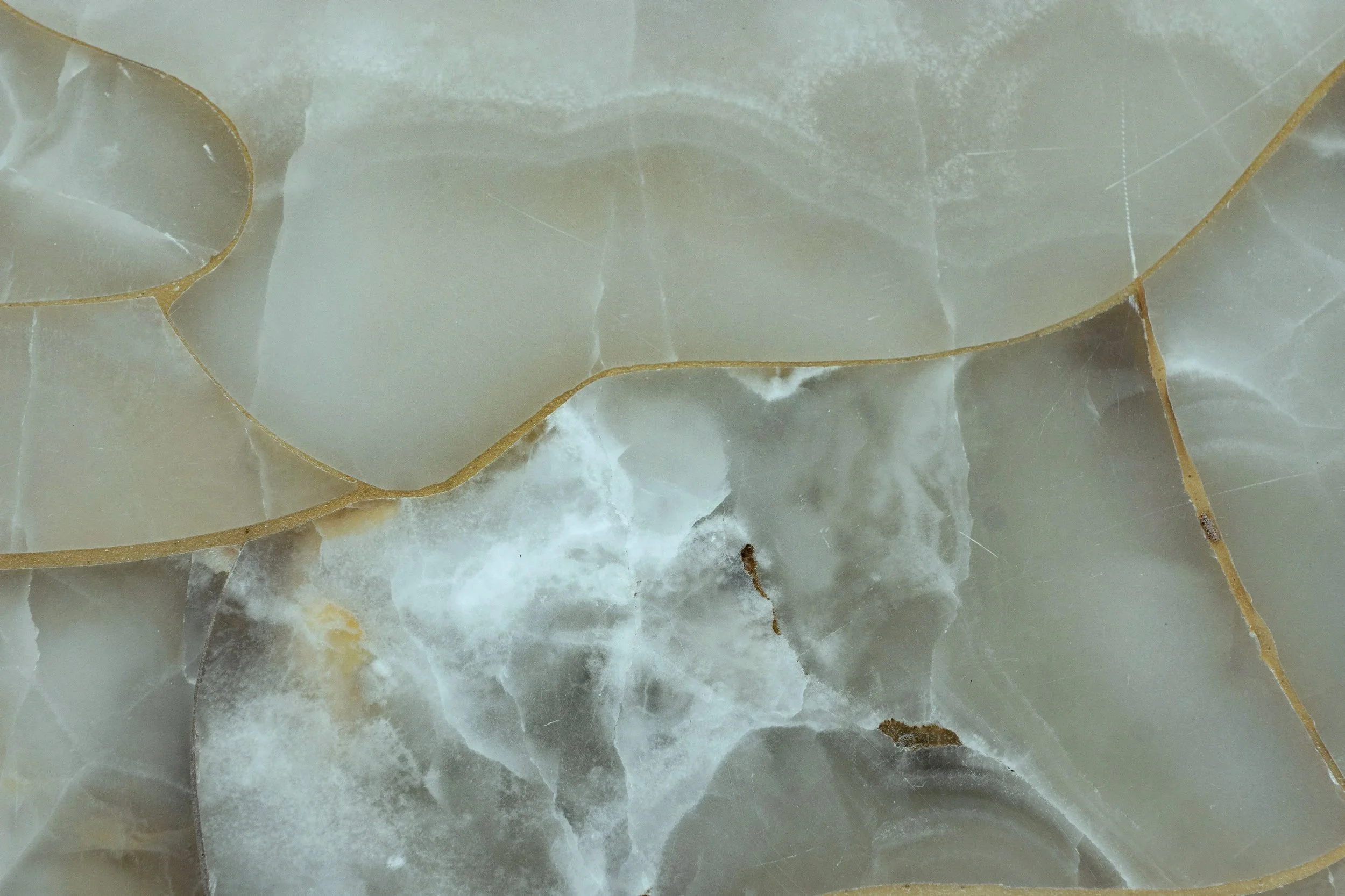Close-up of broken marble or stone surface with large cracks and fractured pieces.
