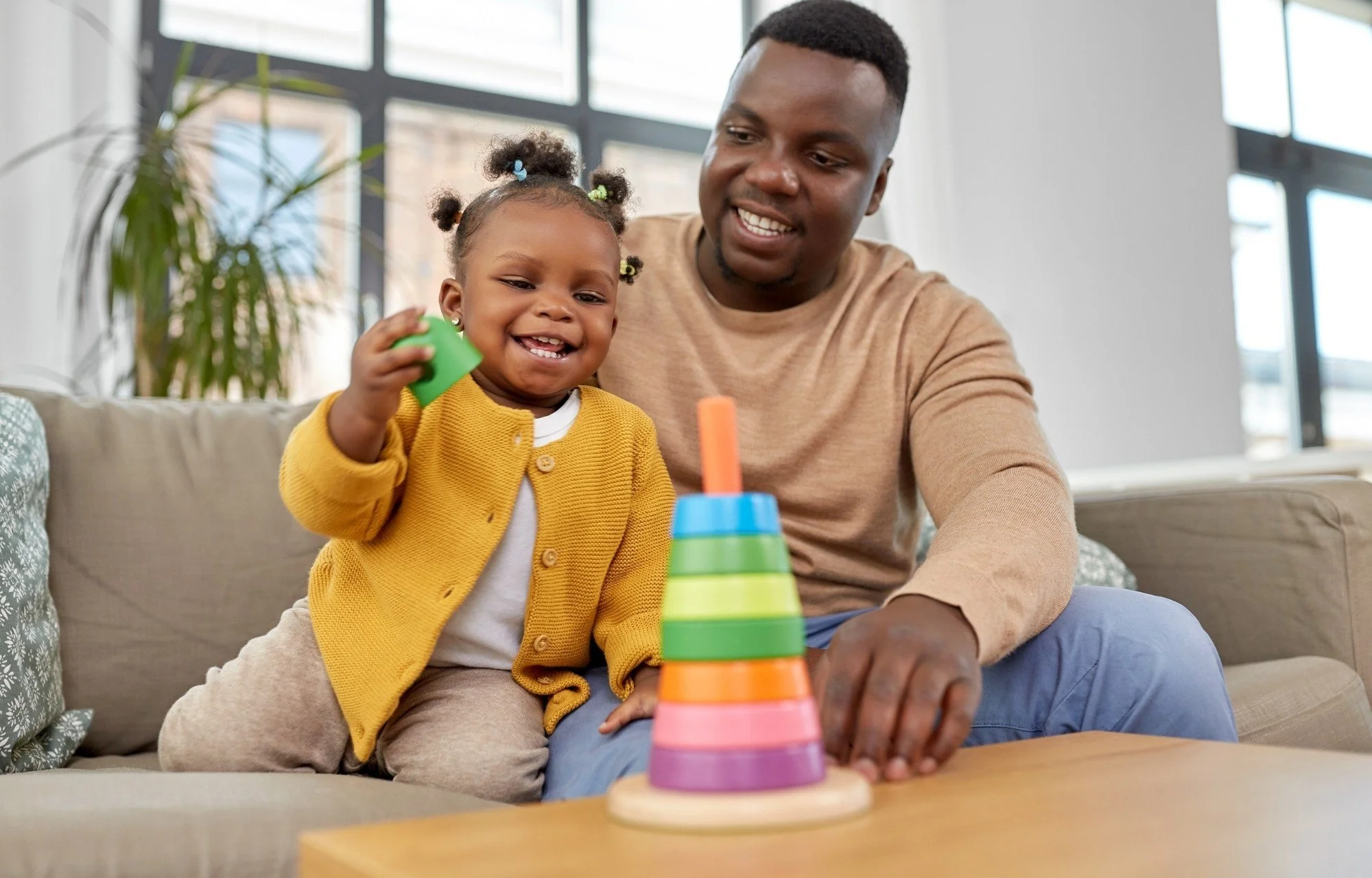 Child and caregiver playing with a stacking toy next to the intake form for autism support in Thomasville, Davidson County, and Forsyth County, NC.
