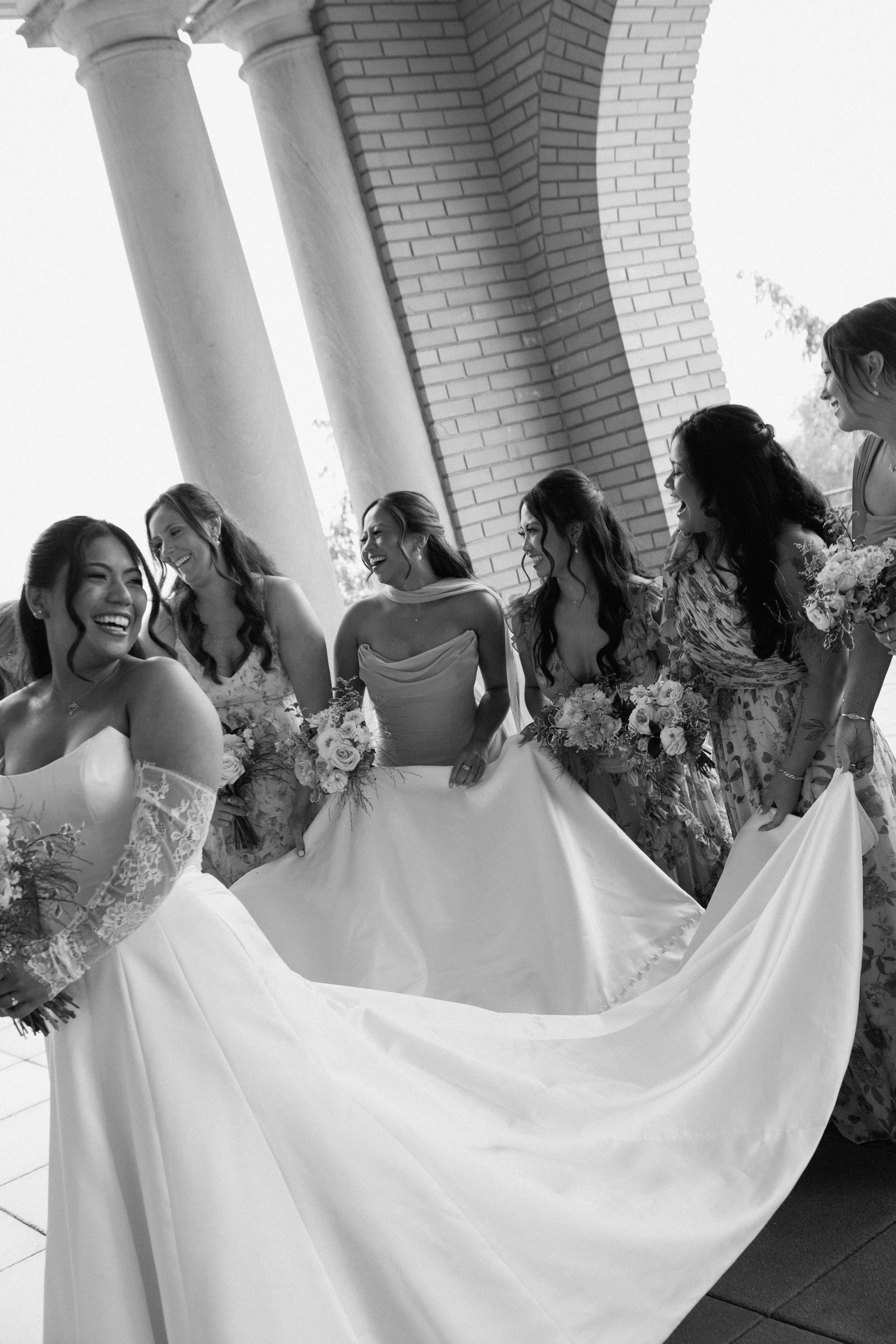 Bridesmaids holding train of bride's dress