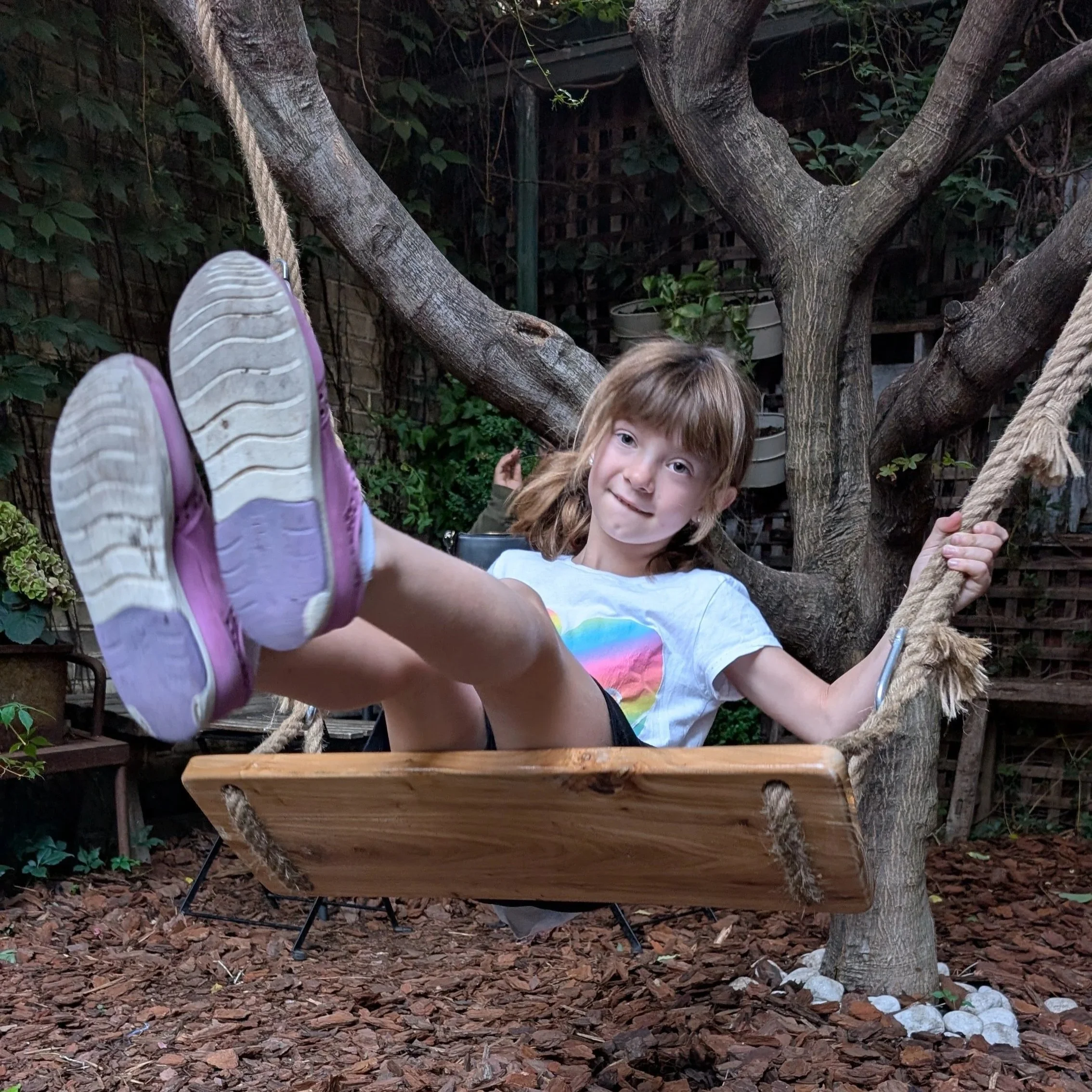 Maddie on a swing in Cafe 23 hidden garden