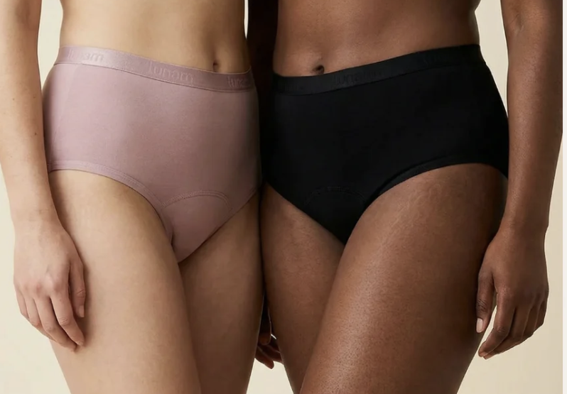Close-up of two women wearing high-waisted underwear, one in pink and the other in black, standing side by side.