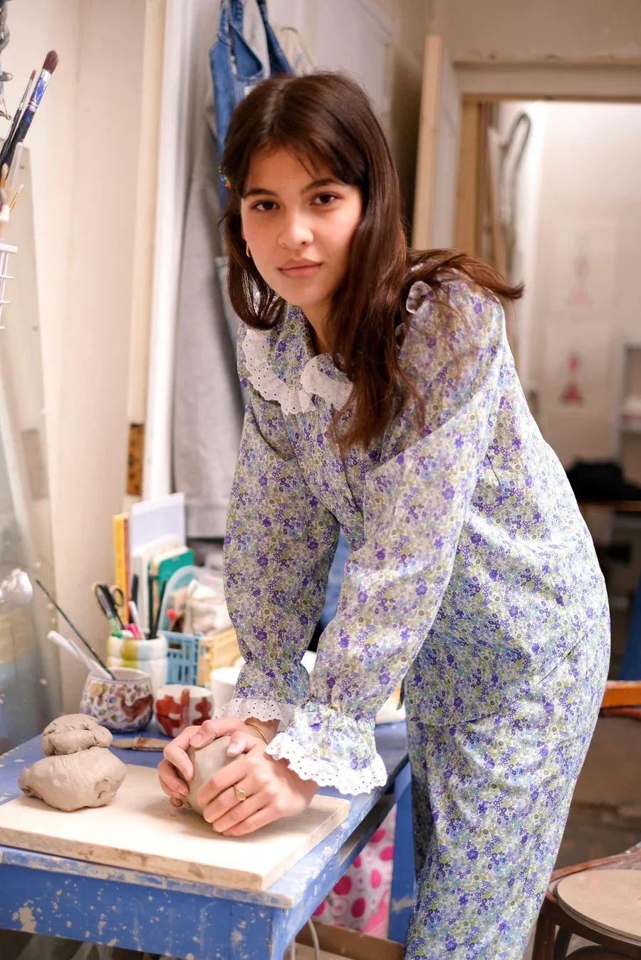 Young woman working with clay on a wooden board in a creative studio