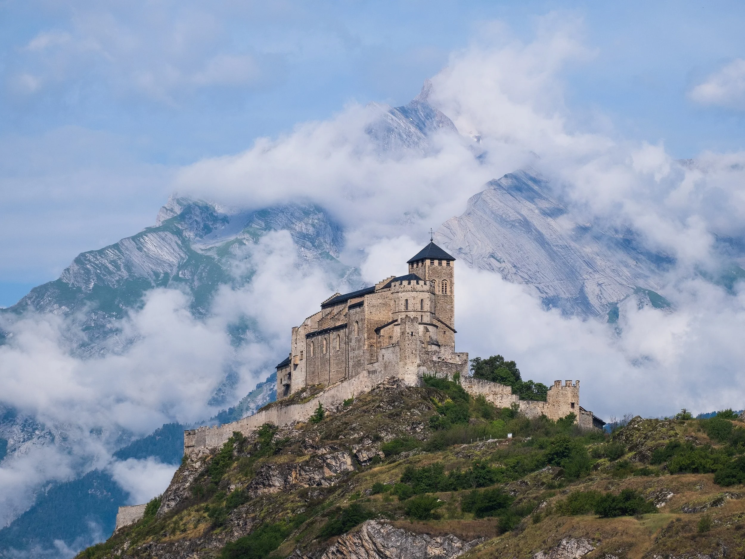 Le château de Valère devant le Haut de Cry nuageux en arrière-plan.