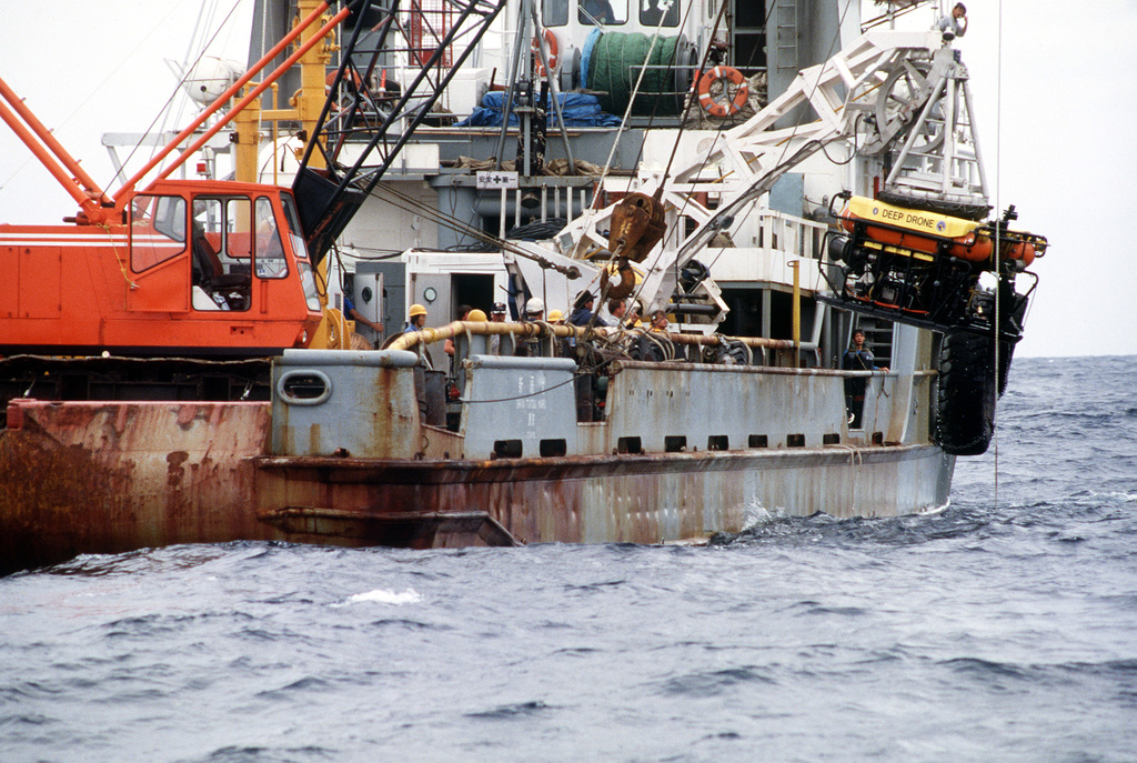 A fishing boat on the water equipped with a crane and equipment, including a drone labeled 'Deep Drone'.