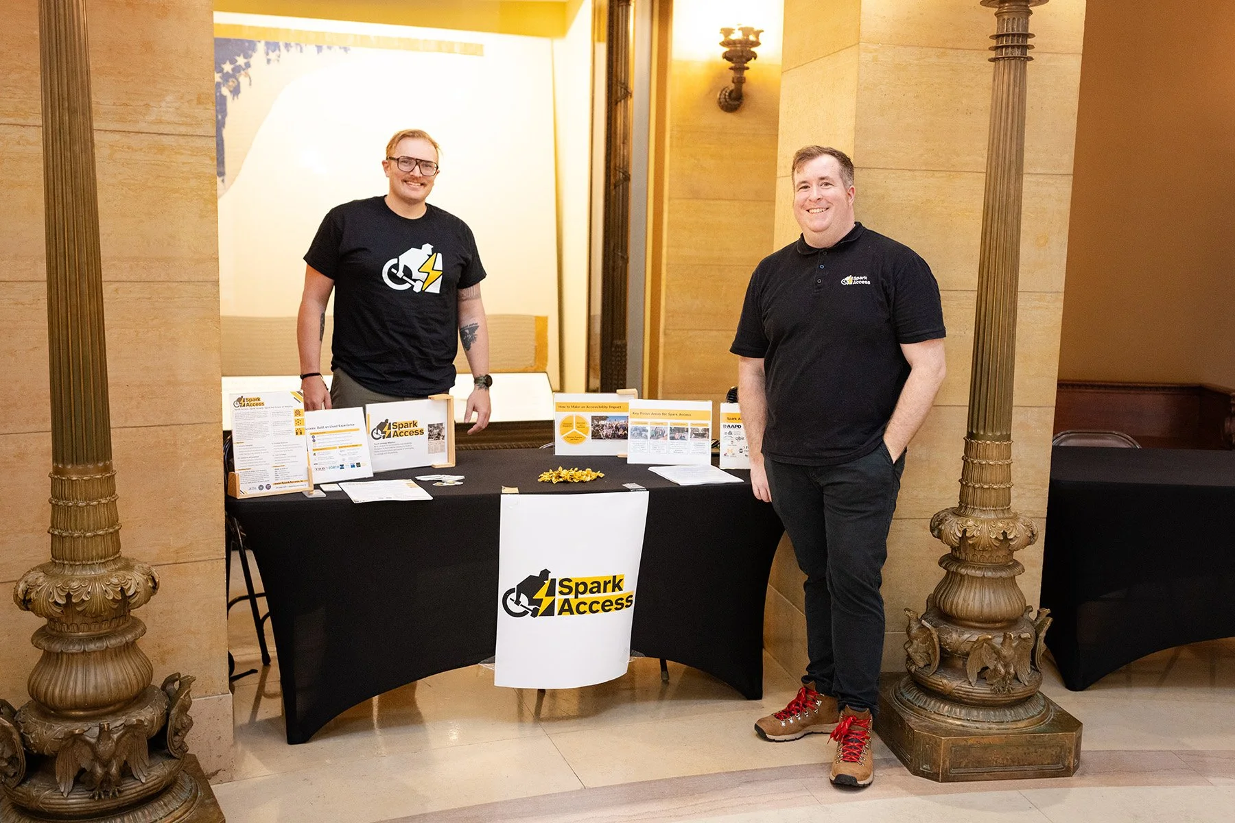 A photo of Alan and a coworker at a Spark Access booth.