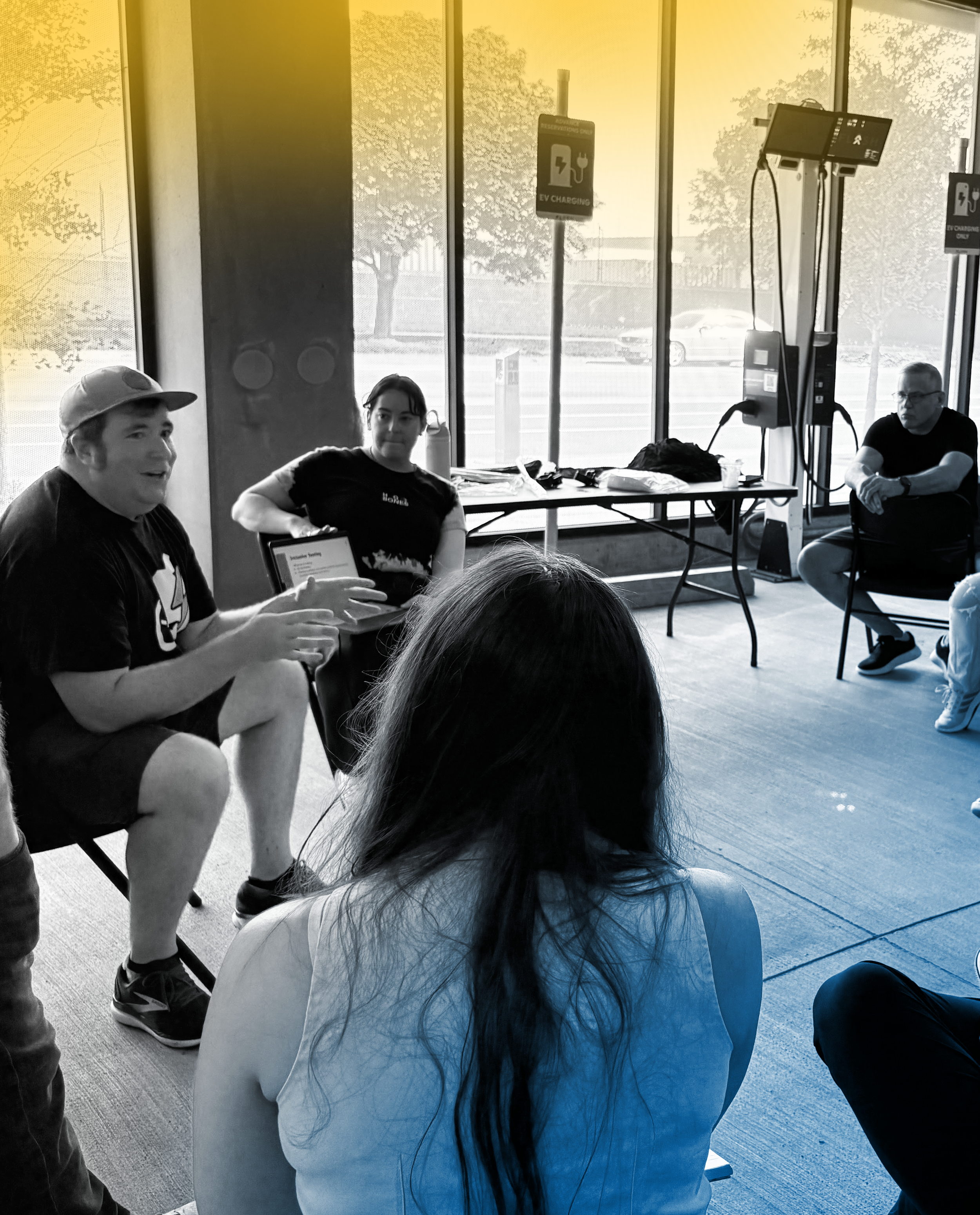 Alan Hejl speaking on a panel with Ani Grigorian, in a wide open room with concrete floors and large windows.