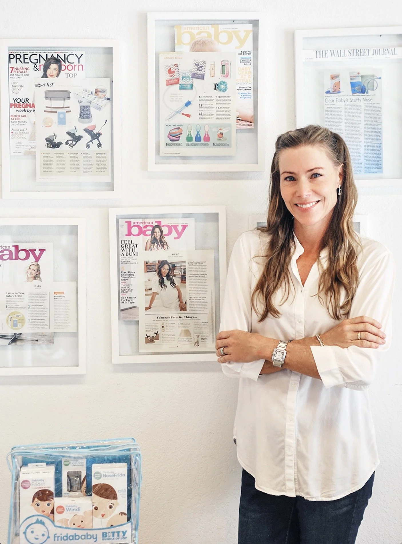 Kaisa Levine, founder of Fridababy, stands in front of framed press clippings and marketing materials at Fridababy's Miami offices