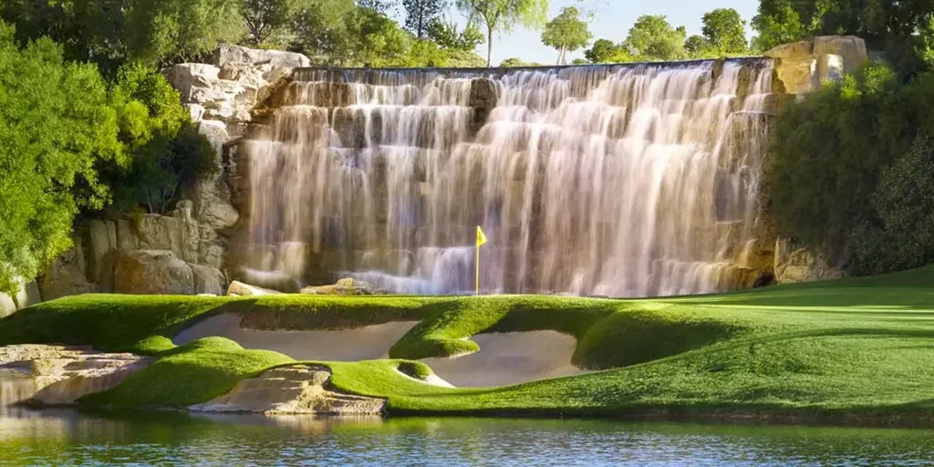 The Wynn Golf Course with a waterfall and lush greenery.