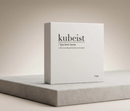 A white box of Kubeist hair care product on a grey surface against a beige background.