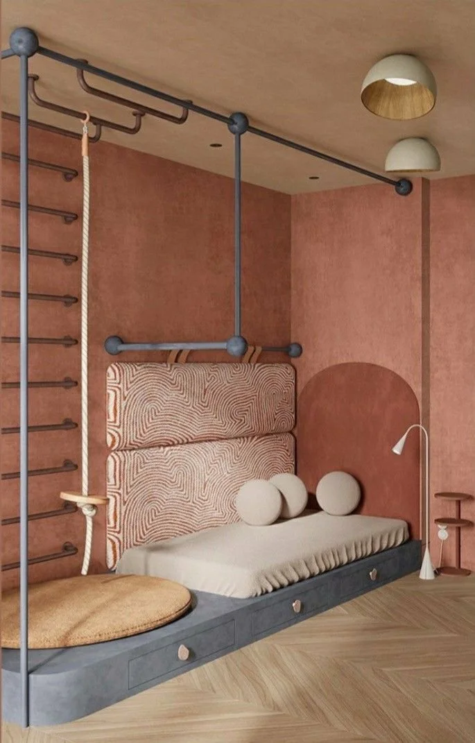 Interior of a bedroom with a bed built into the wall, featuring a padded headboard and round cushions. The room has a pink textured wall, modern lighting fixtures on the ceiling, a hanging rope with a wooden seat, and safety bars and climbing ladder for exercise or play.