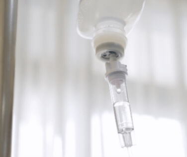 Close-up of an intravenous (IV) drip hanging from a hook.