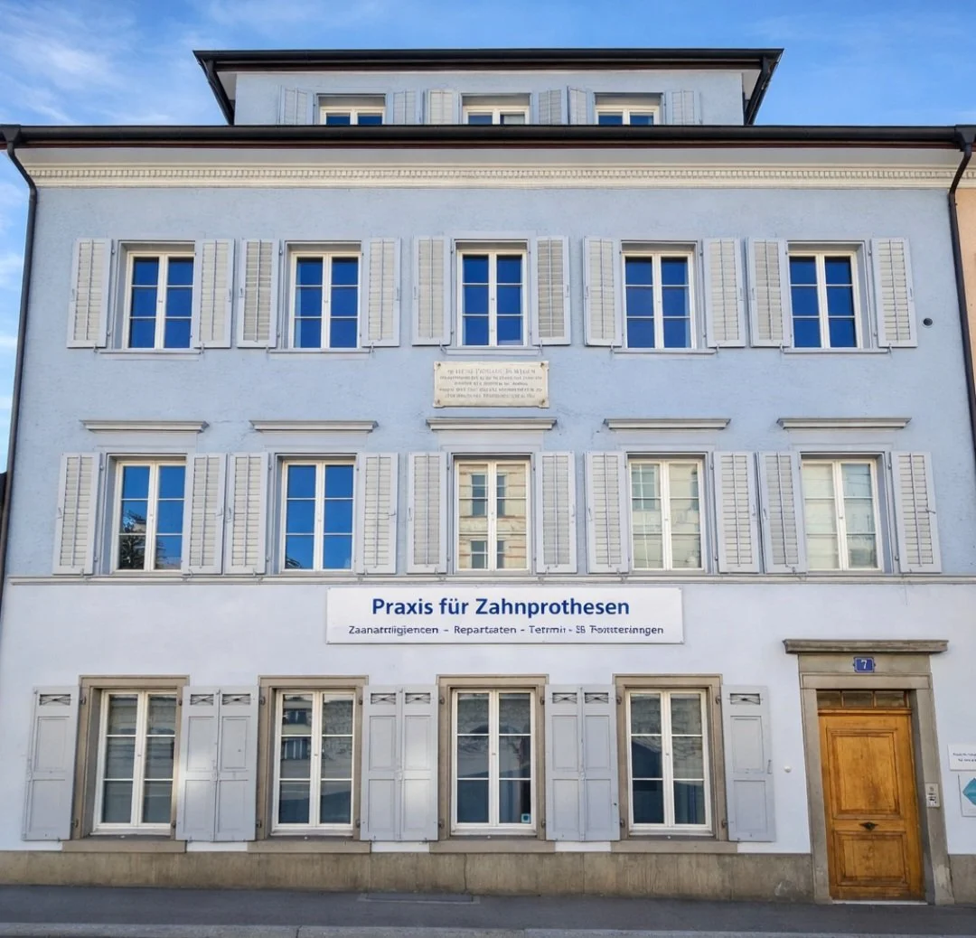 Das Gebäude ist eine weiße Praxis für Zahnprothesen mit mehreren Fenstern und weißen Fensterläden. Es gibt ein großes Schild mit der Aufschrift 'Praxis für Zahprothesen' und einer Liste der angebotenen Dienstleistungen. Das Gebäude hat eine Holztür und eine Adresse 7.