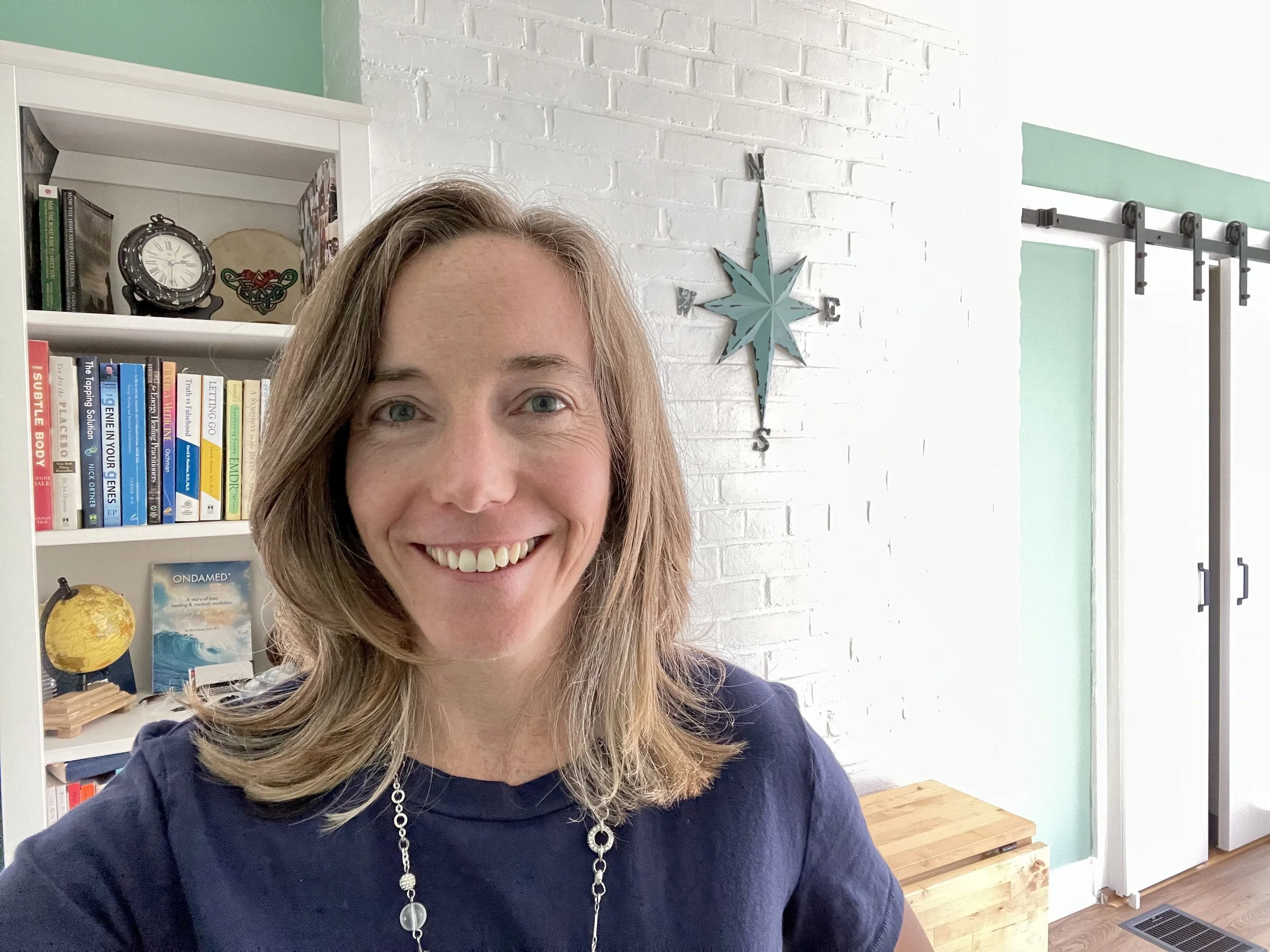 Mary VonO smiling in her office beside bookshelves