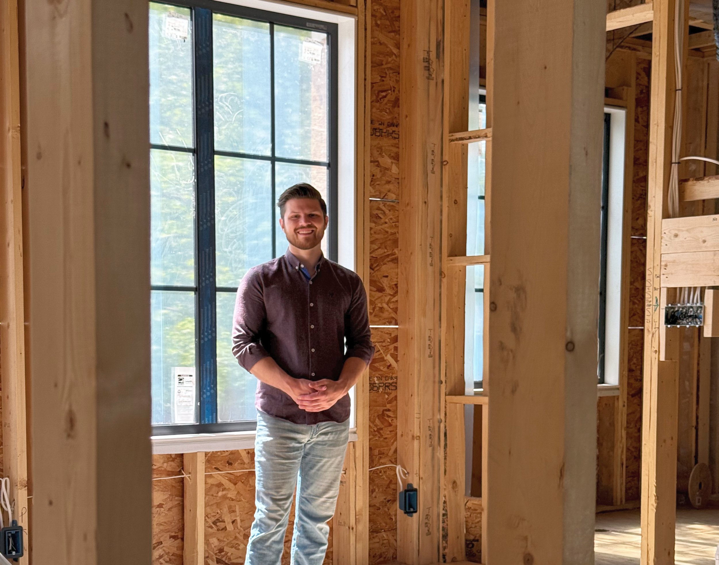 Ryan Cairns standing in a partially constructed custom luxury home.