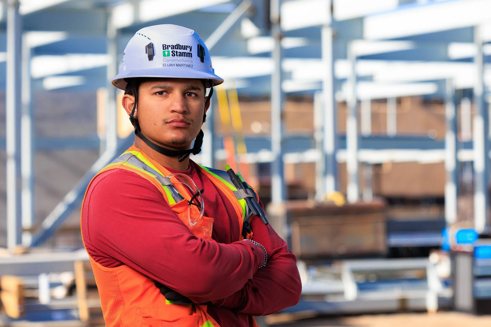 Construction worker wearing a helmet and safety vest at a construction site.