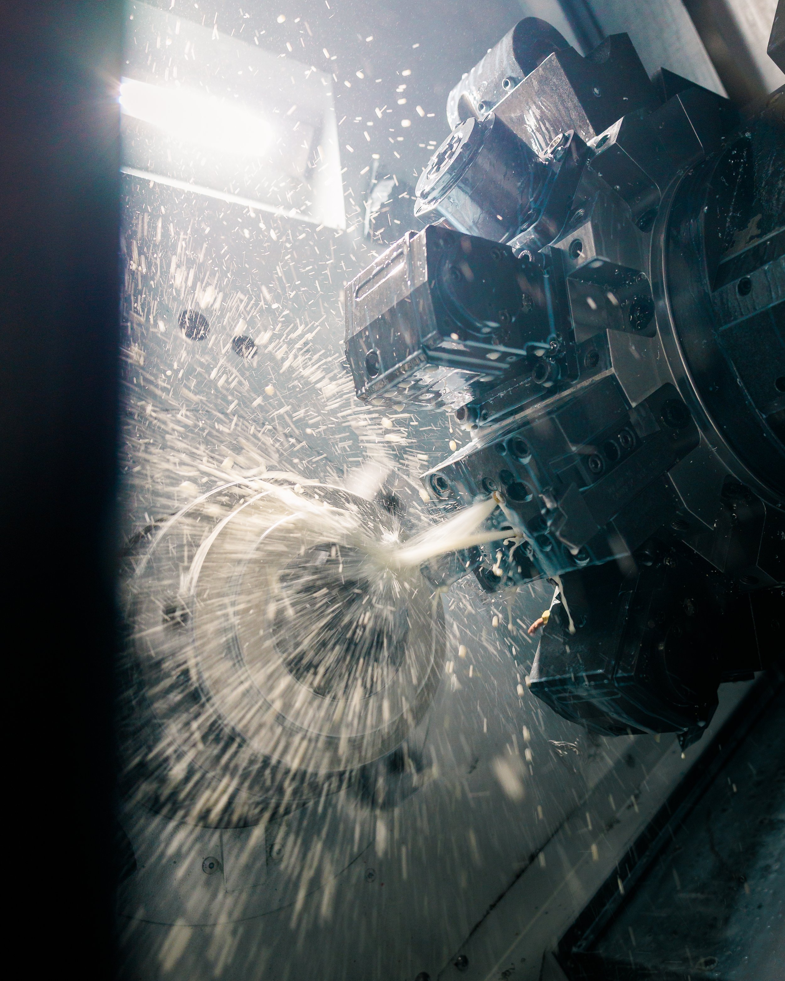 Close-up of a CNC machine cutting metal, with sparks flying as the tool engraves the material.