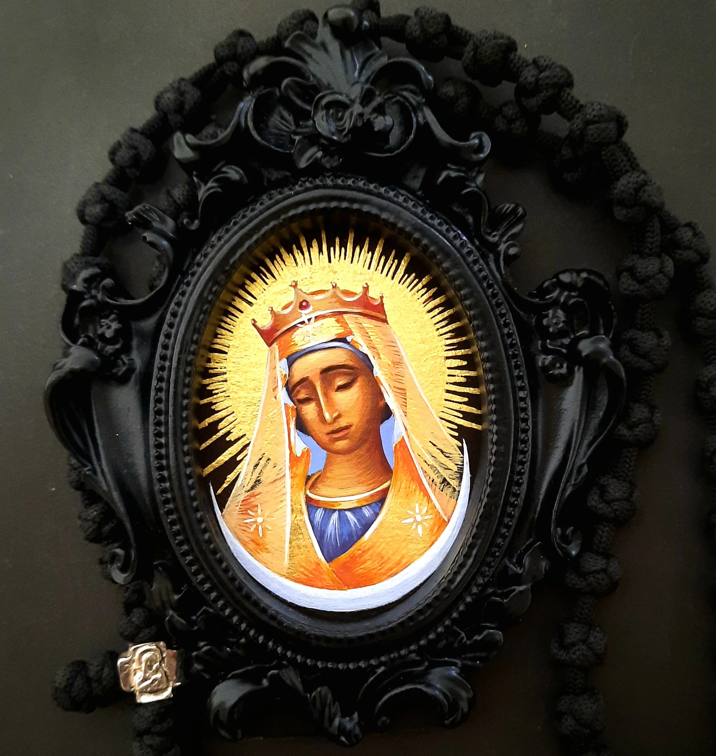 The icon depicts the Virgin Mary with a golden background, a crown, and a golden halo of rays.
