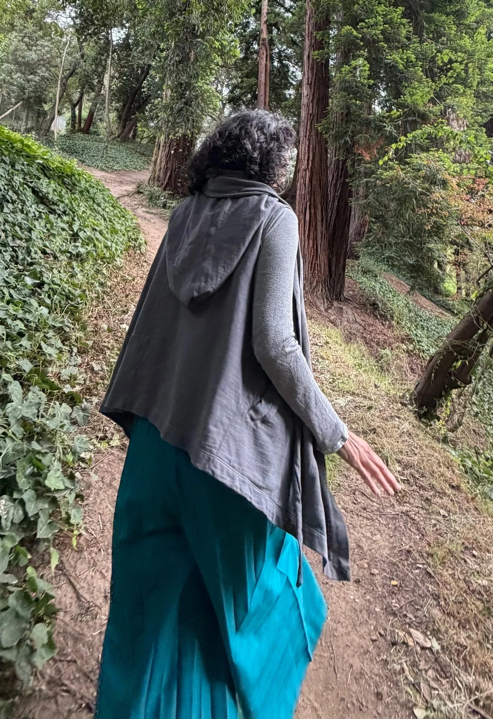 Erica Ando walking along a wooded path.