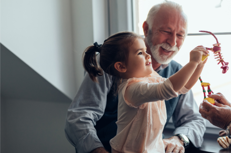 Grandfather and young girl playing with a colorful toy together.