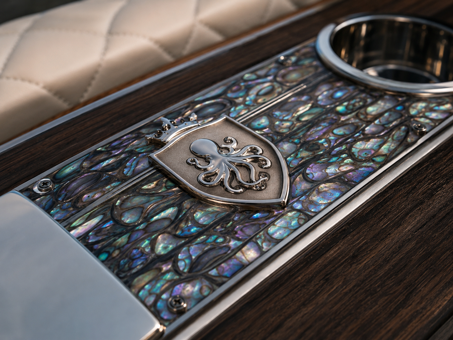 Close-up of a dashboard featuring iridescent abalone shell inlays, a crest with an octopus emblem, and a circular metal bezel, all on a dark wood surface.